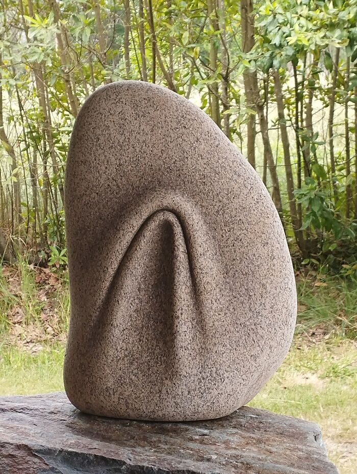 Sculpture resembling folded fabric, showcasing soft stone illusion in a natural setting.