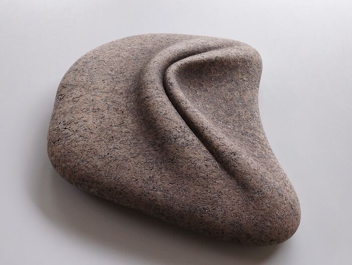 Smooth stone sculpture with soft, flowing curves, appearing to defy physics.