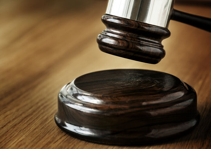 Wooden gavel resting on a desk, symbolizing an unethical life hack in legal context.