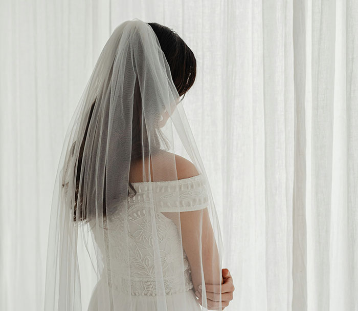 Bride in wedding dress and veil, symbolizing elaborate marriage scam involving influencer.