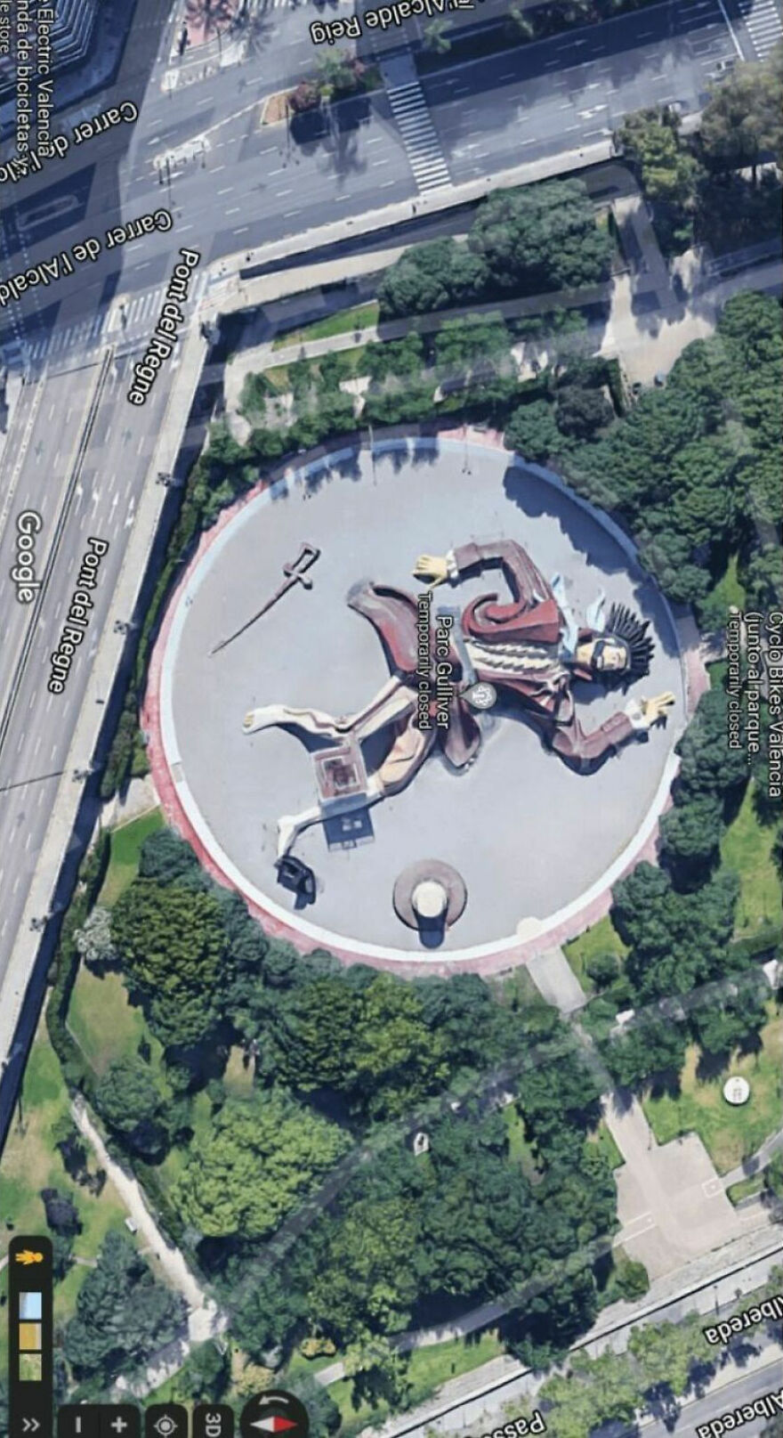 Giant Gulliver figure in a park found on Google Earth, surrounded by trees and roads.