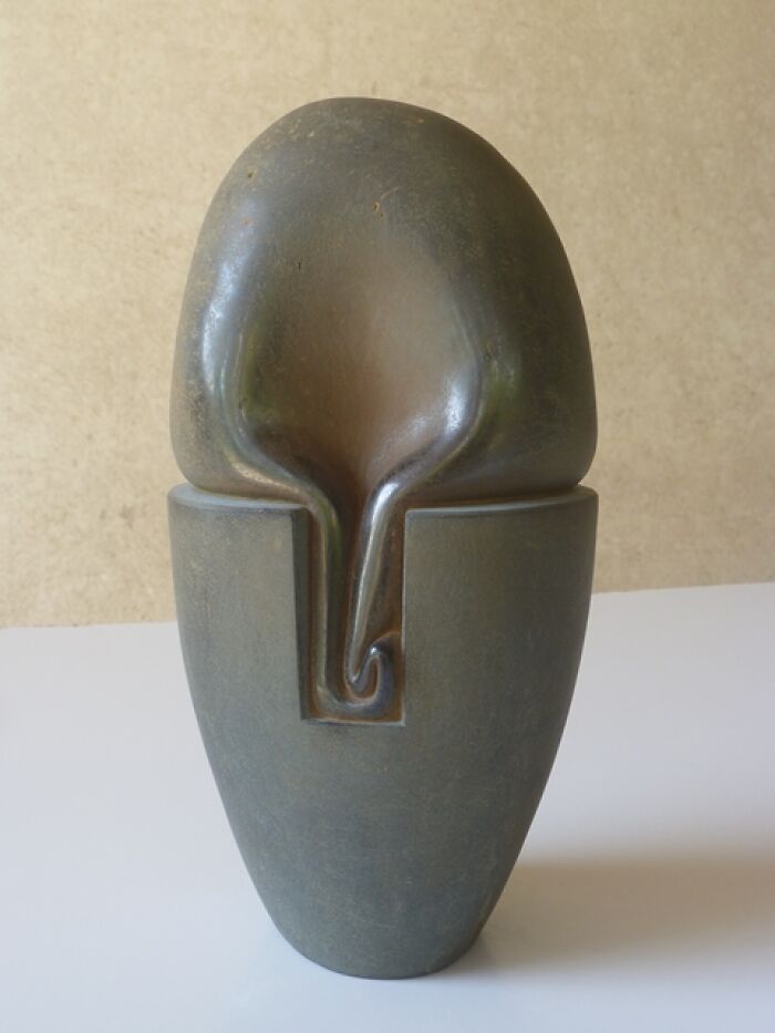 Abstract sculpture resembling a stone vase, showcasing soft, fluid curves that defy physics.