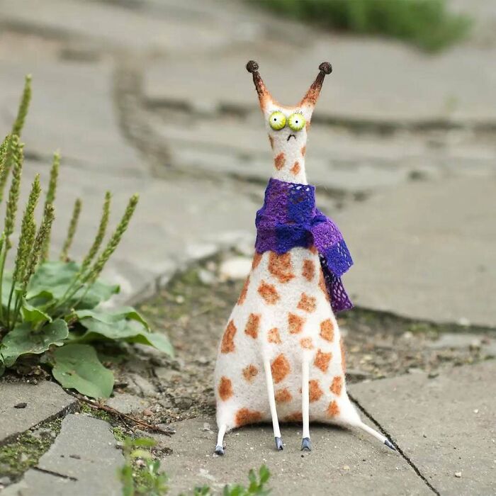 Funny-looking animal doll with spots and a purple scarf, created by a Georgian artist.