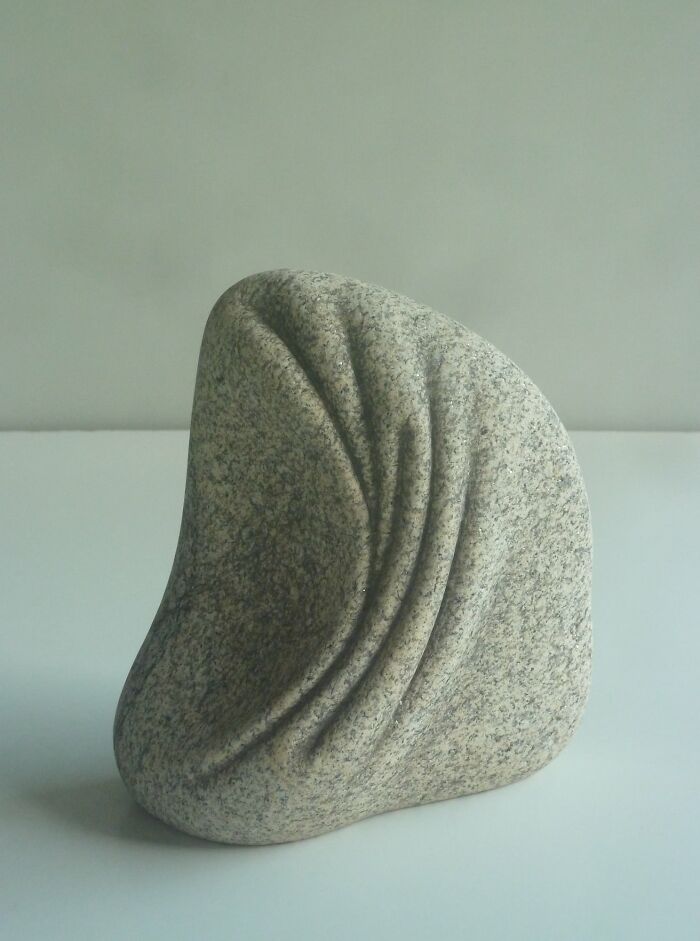 Smooth stone sculpture with soft folds, showcasing intricate design that defies physics.