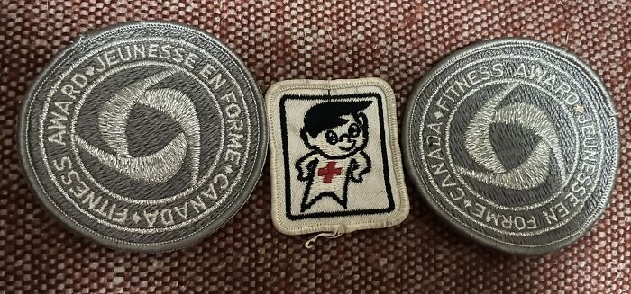 Gen X fitness award patches and a vintage medical character patch on brown fabric.