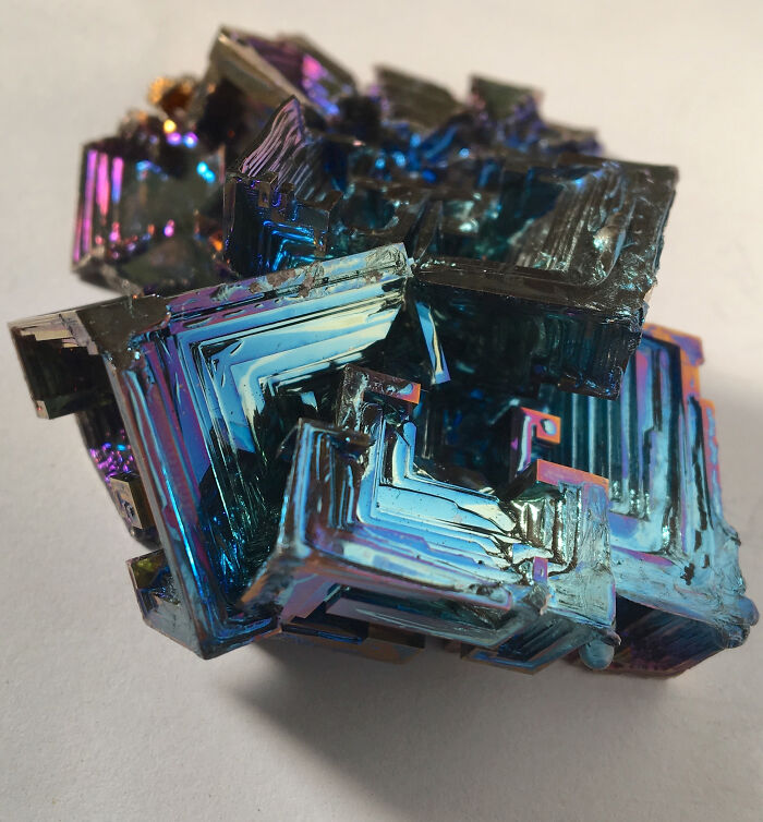 Colorful, geometric crystal showcasing stunning natural phenomena with iridescent surfaces reflecting light.