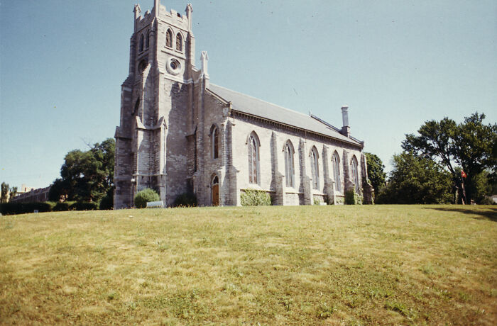 Historic stone church on a hill, showcasing fascinating architecture and surrounded by trees.