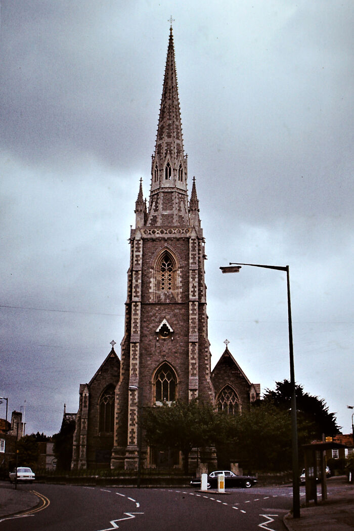 Gothic church with a towering spire against a cloudy sky, highlighting fascinating church architecture.