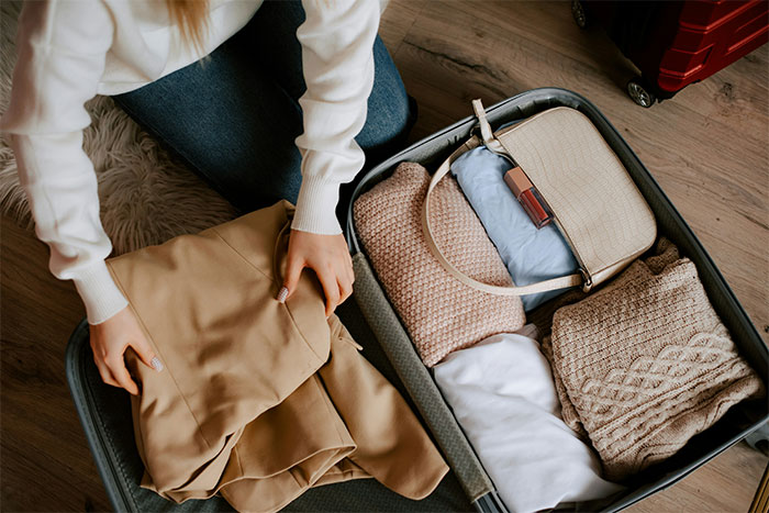 Woman packing suitcase, symbolizing betrayal and emotional distance.