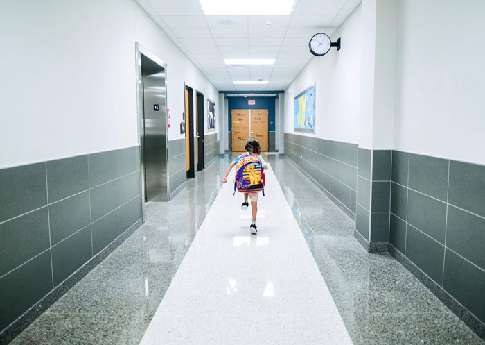 Child with a backpack running down a school hallway, evoking unsolved true crime cold cases.