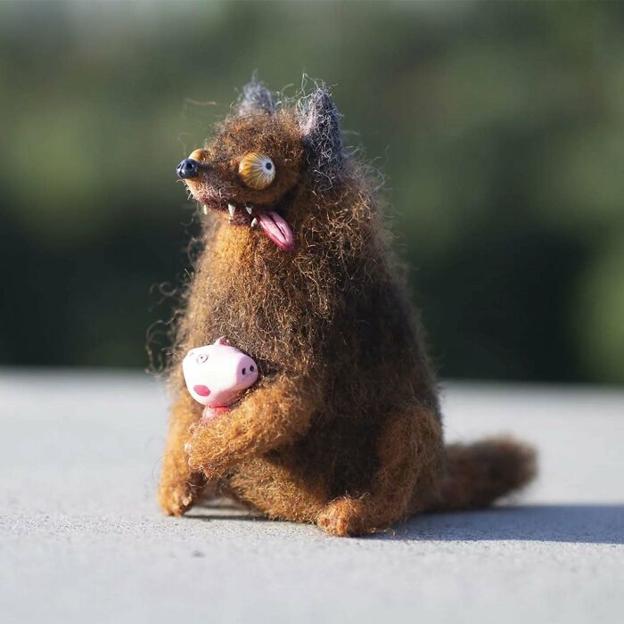 Funny-looking art doll of an animal holding a small pink creature, created by a Georgian artist.