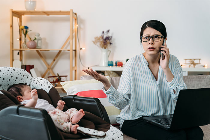 Woman on phone beside a baby, illustrating teen's refusal of babysitter role.