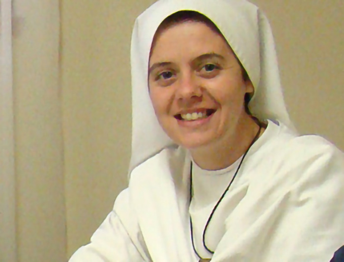 A smiling woman in a nun's habit, formerly a "Wild Child" actress, seated indoors.