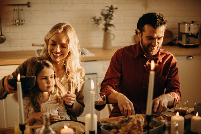 Family enjoying dinner together, highlighting dad's focus on daughter's safety, health, and happiness.