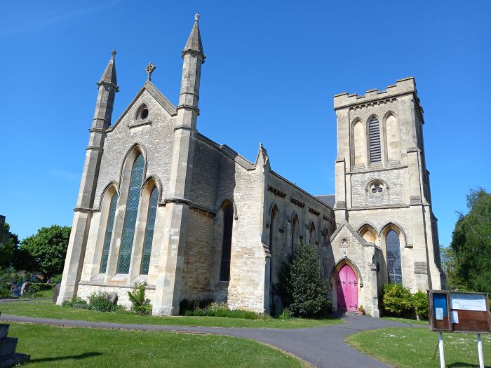 Historic stone church with tall spires under a clear blue sky.