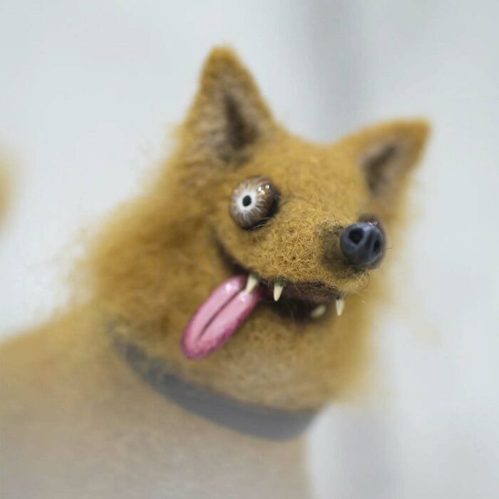 Funny-looking animal doll with fuzzy fur, crooked eyes, and tongue out, created by a Georgian artist.