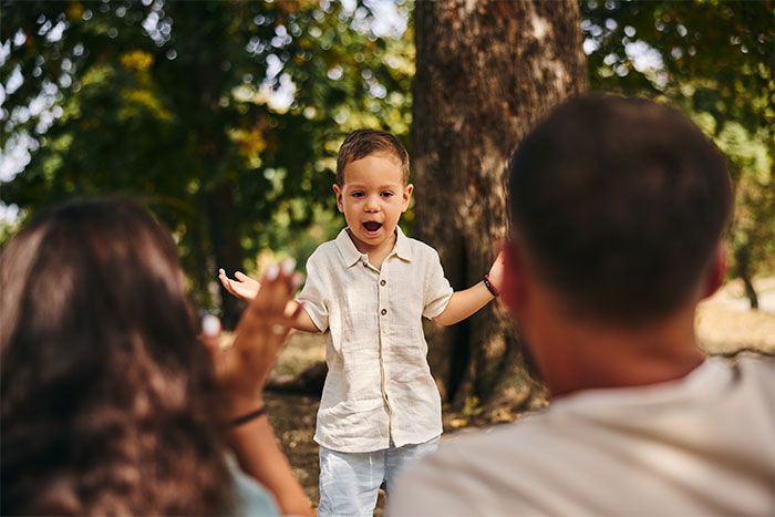 Child playing outdoors with adults, highlighting family dynamics and babysitting themes.