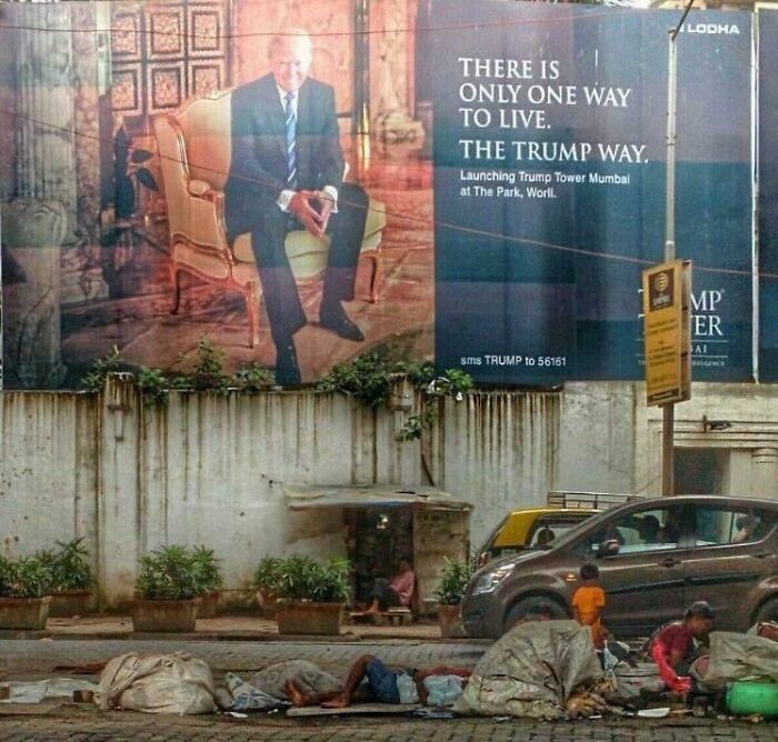 Urban hell depiction with a lavish billboard above a street where homeless people are lying, highlighting stark contrast.