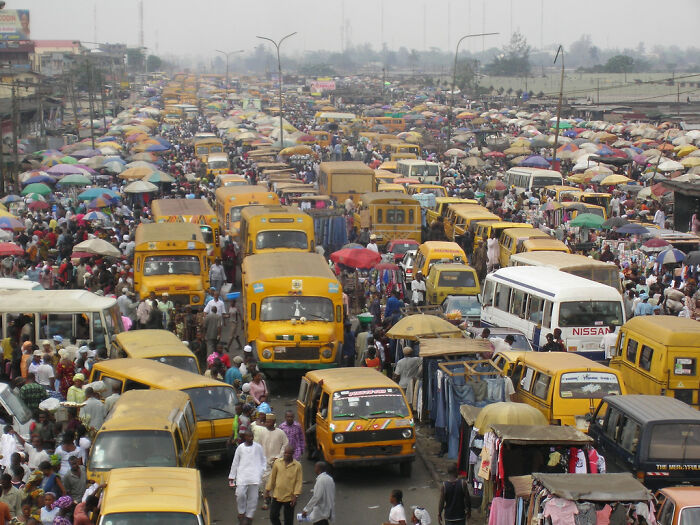 Crowded urban scene with heavy traffic and pedestrians, showcasing an example of an 'urban hell' environment.