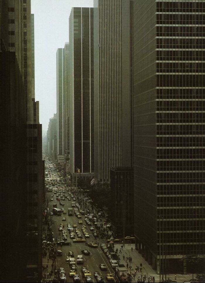 Urban hell depiction with crowded street and tall buildings, creating a claustrophobic city atmosphere.