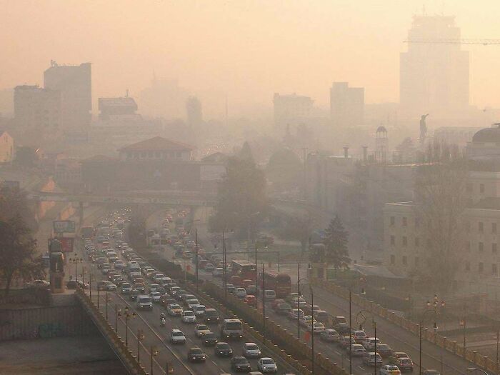 Traffic and smog in a dense urban area, illustrating urban hell conditions with poor air quality and congestion.