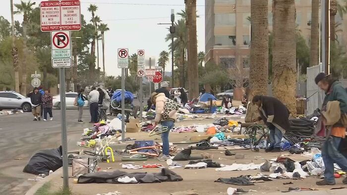 Urban scene with litter and people, depicting urban hell.