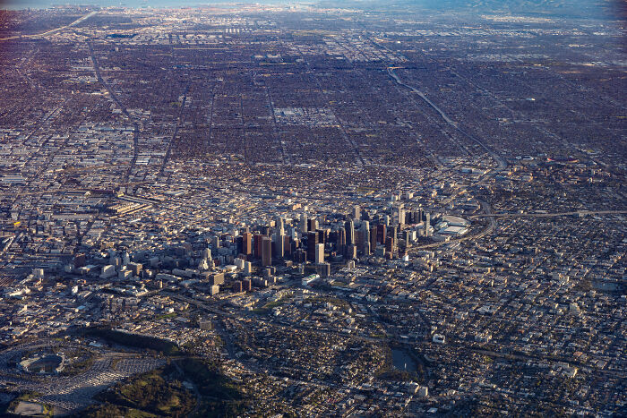 Aerial view of a sprawling city landscape illustrating urban hell, with dense buildings and endless grid-like structures.