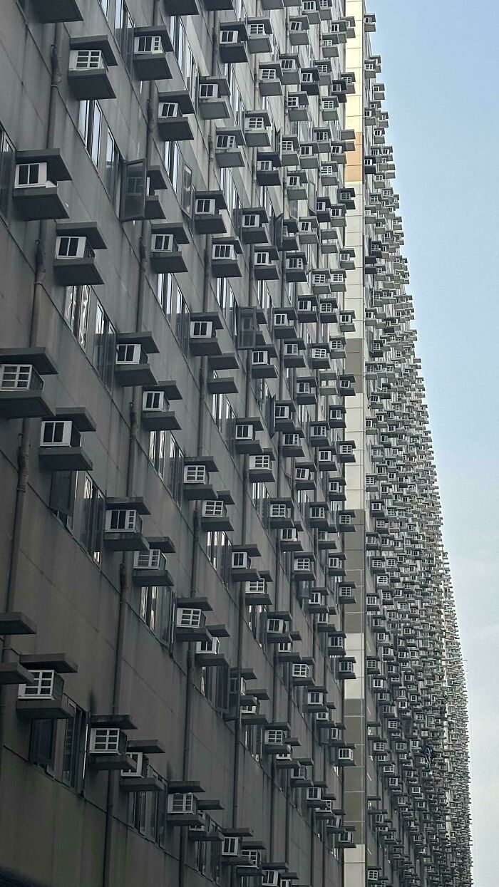 High-rise building with countless air conditioning units exemplifying urban hell.