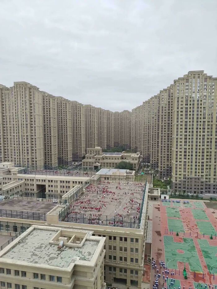 Massive residential buildings closely packed under a cloudy sky, showcasing an urban hell landscape.