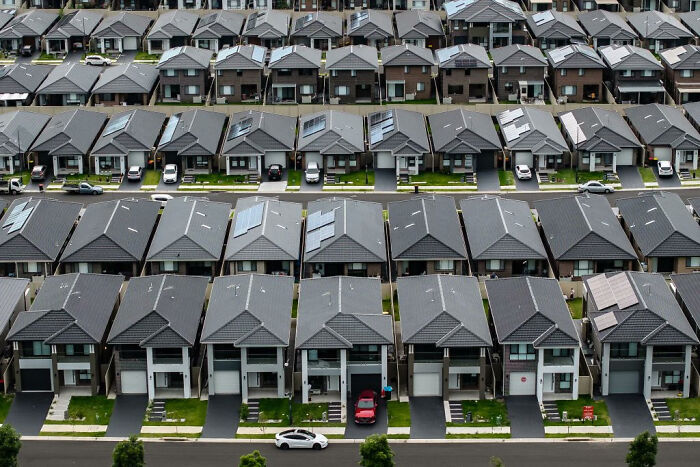 Aerial view of uniform suburban houses, illustrating urban hell with repetitive and dense housing layout.