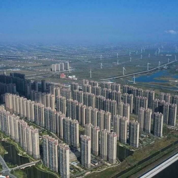 Dense urban landscape with rows of identical high-rise buildings under a clear sky, exemplifying urban hell.