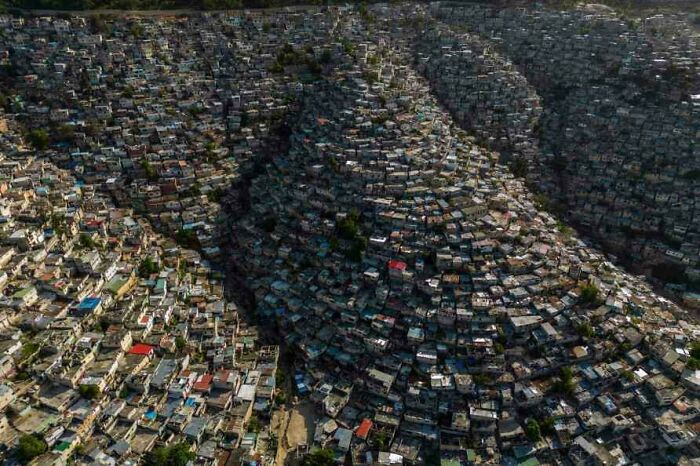 Aerial view of densely packed urban area with houses on steep hills, illustrating extreme urban hell conditions.