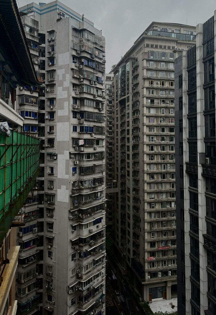 Crowded urban skyline with dense, deteriorating high-rise buildings creating an 'urban hell' atmosphere.