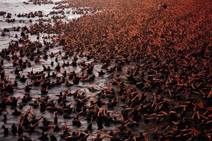 Crowd of people in dark water, symbolizing the symphonic chaos of modernity.