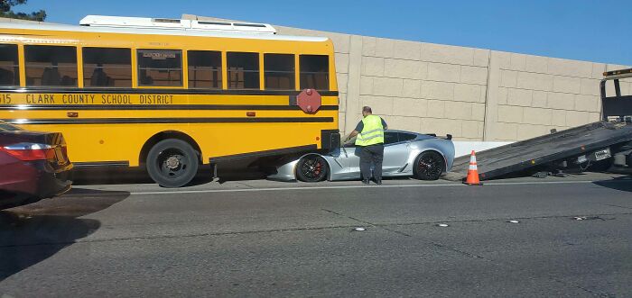 Bus and sports car accident being handled by a worker wearing a safety vest.