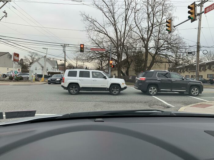 Cars blocking intersection at red light, illustrating bad driving behavior.