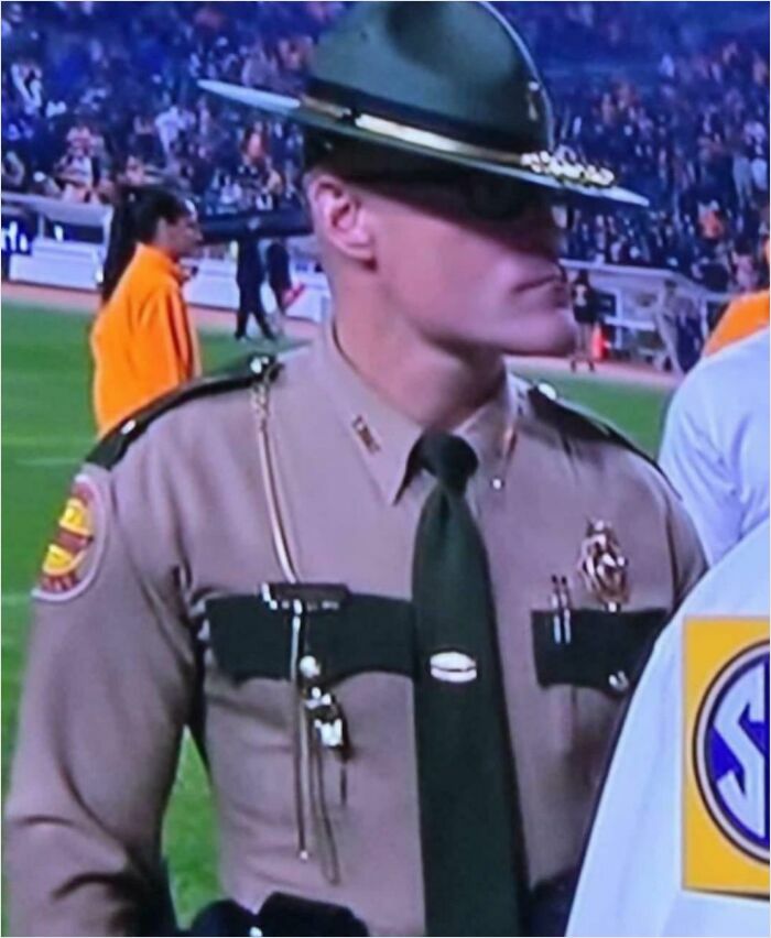 Officer in uniform on a sports field, showcasing absolute units things theme.