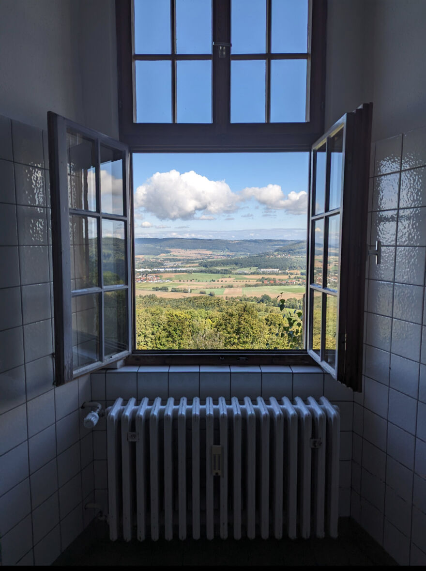 Open window view of a stunning landscape framed by bathroom tiles, showcasing a unique accidental art composition.