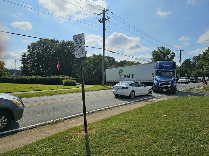 A truck and a car awkwardly positioned on a narrow street, highlighting a traffic mishap involving vehicles.