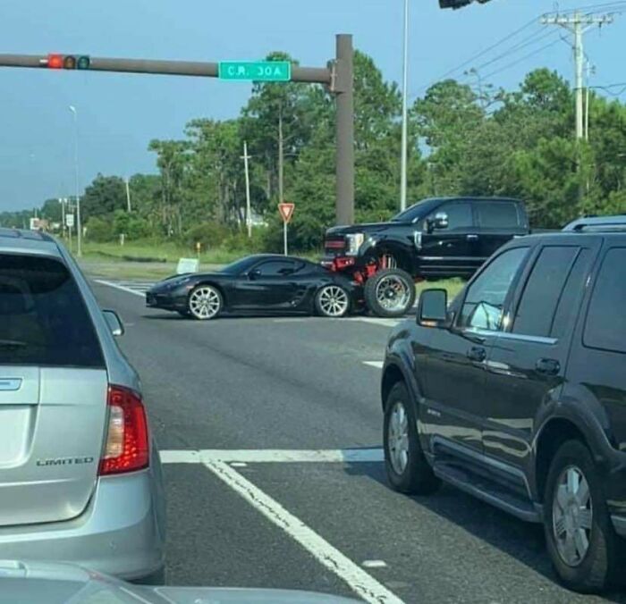 Two cars in a traffic mishap at an intersection.