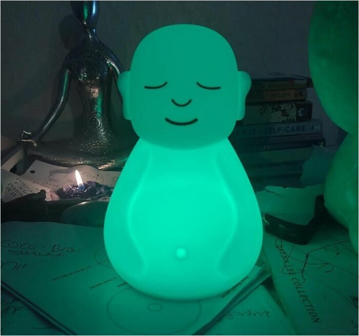 Glowing green Buddha lamp on desk, symbolizing new hobbies 2025.