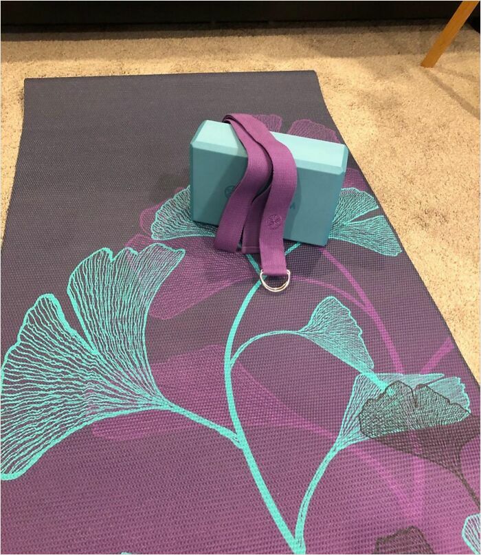 Yoga mat with a floral pattern, paired with a teal block and purple strap, illustrating new hobbies in 2025.