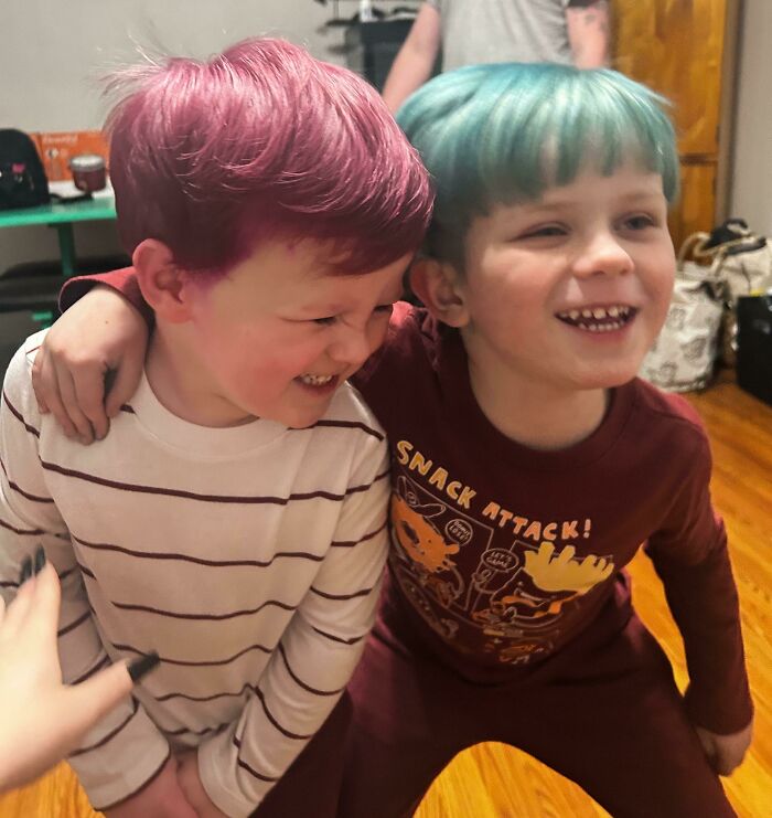 Two children with colorful hair enjoying time together indoors, showcasing changing hair color.