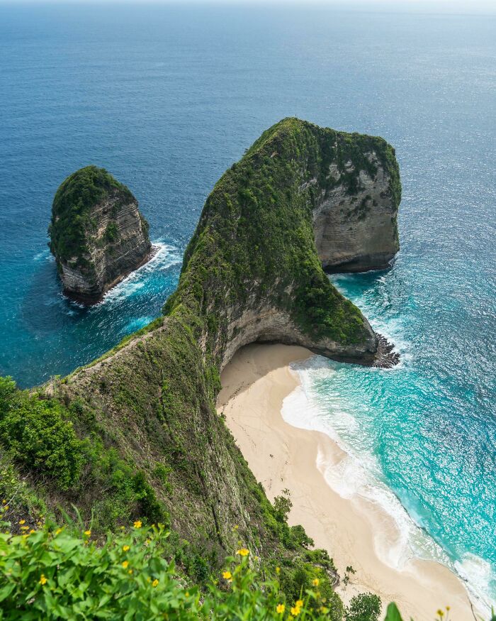 Stunning aerial view of Kelingking Beach's turquoise waters and dramatic cliffs, showcasing incredible world photos.