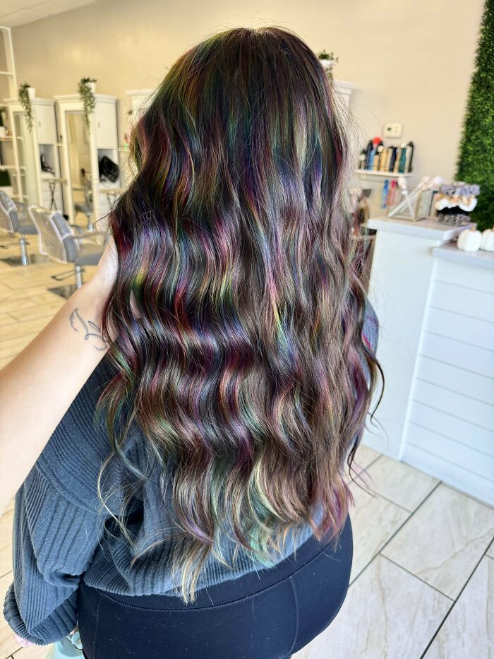 Wavy multicolored hair in a salon, showcasing changing hair color with vibrant hues.