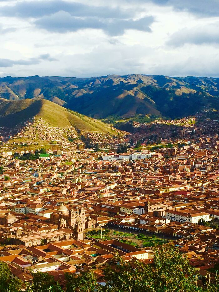 Aerial view of a sprawling cityscape against mountainous terrain, showcasing incredible world photos of urban and natural beauty.