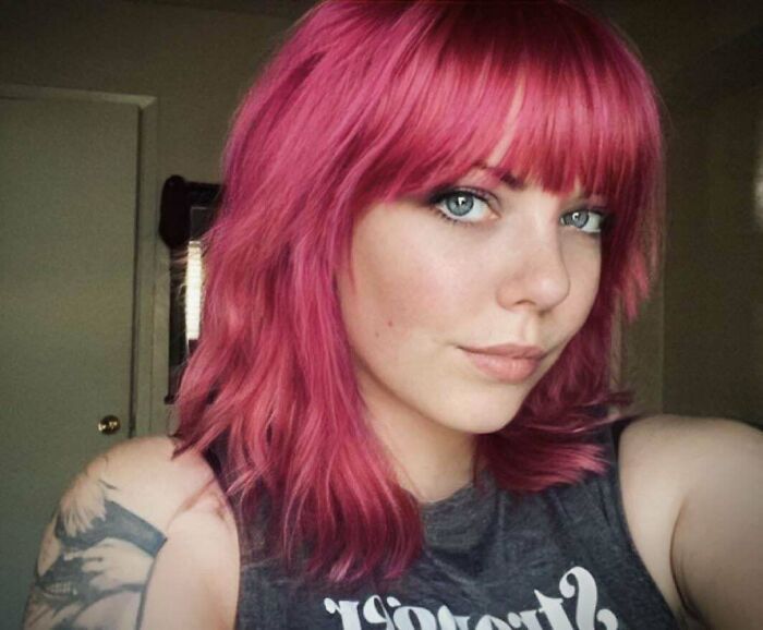 Person with bright pink hair, showcasing a style change in hair color.