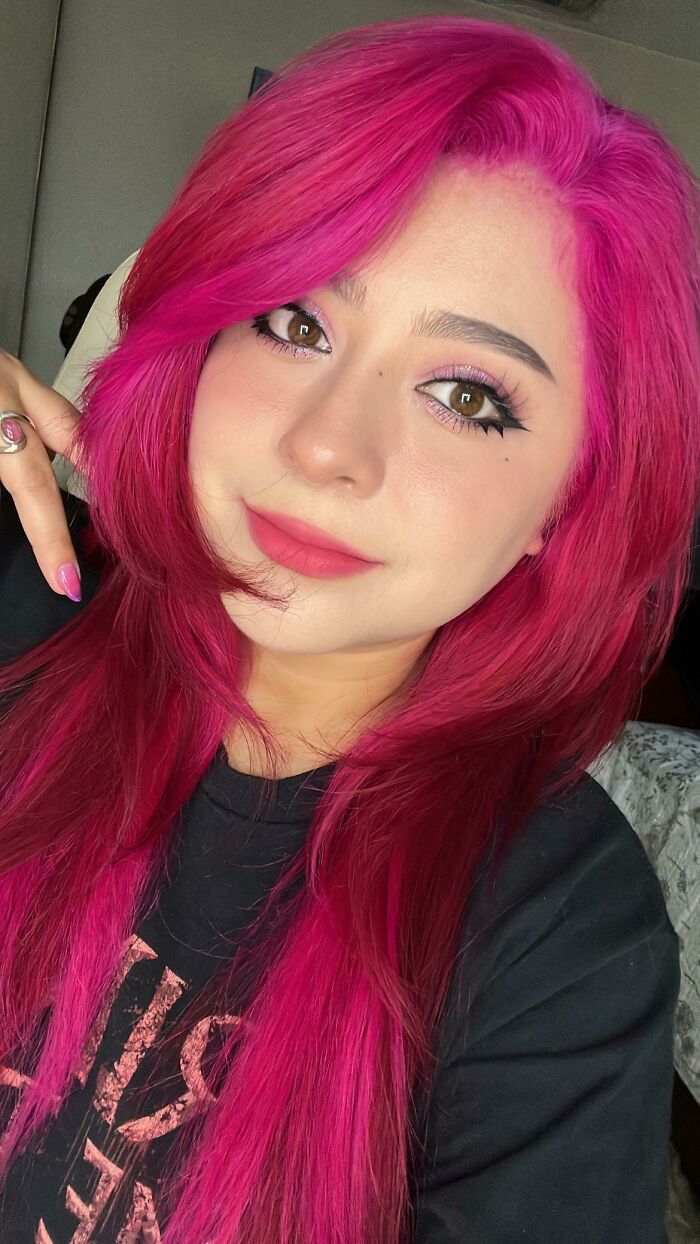 Person with vibrant pink hair showing changing hair color style.