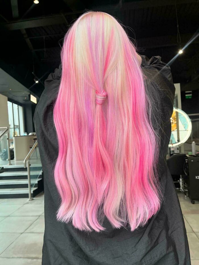 Long pink and blonde hair styled in a salon, showcasing changing hair color trends.