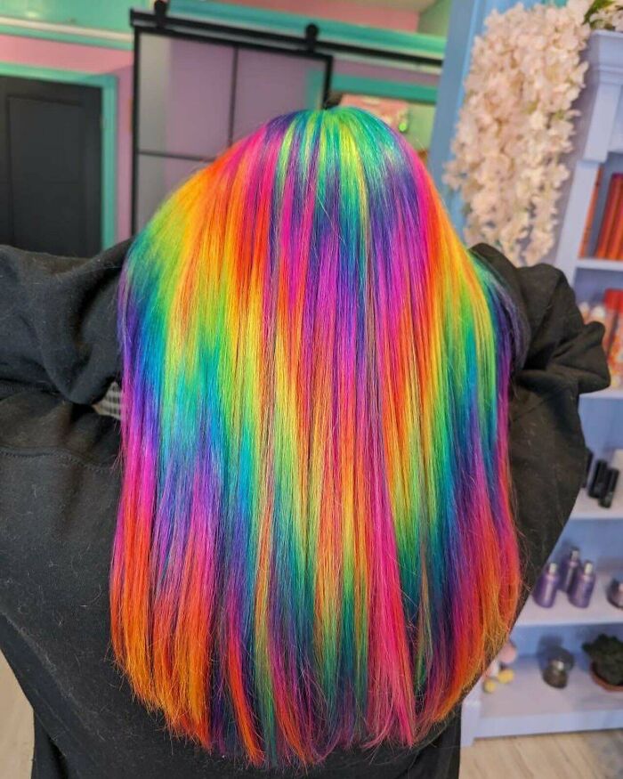 Bright rainbow Changing-Hair-Color on long hair in a colorful salon setting.